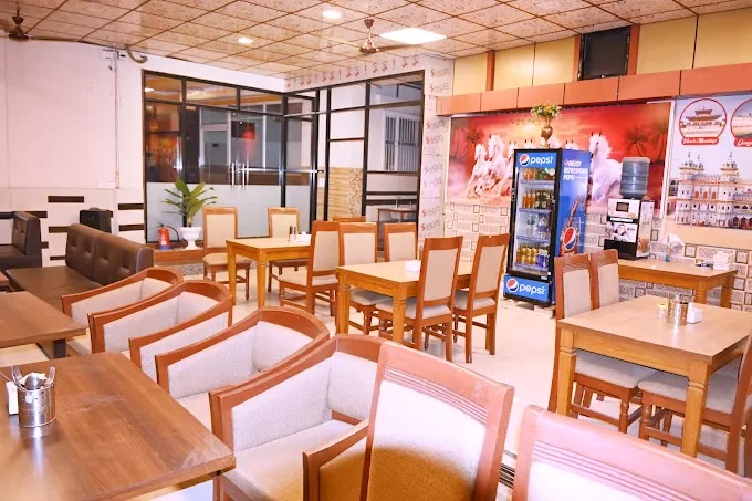 The hotel restaurant: wooden tables, cream upholstered chairs and a sofa along the wall